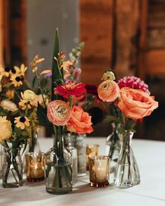 several vases with flowers in them sitting on a table