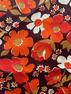 an orange and red flowered fabric with white flowers on it's purple background