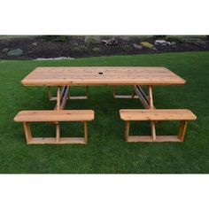 a picnic table with benches in the grass