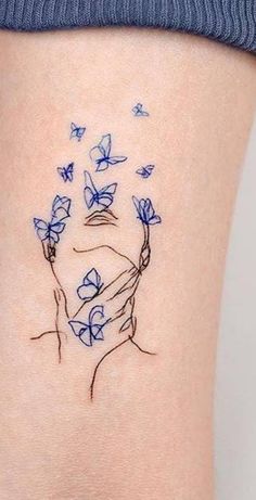 a woman's thigh with blue butterflies flying around her and the word love written on it