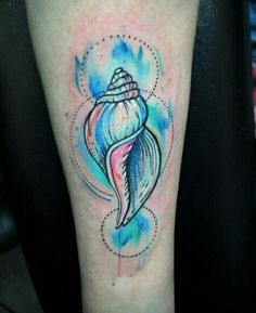 a watercolor style tattoo of a seashell on the right leg with blue and pink colors