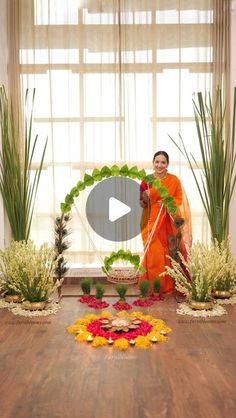 a woman in an orange outfit standing next to flowers and plants