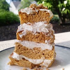 three pieces of cake sitting on top of a plate with white frosting and walnuts