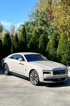 a white car parked in front of some trees