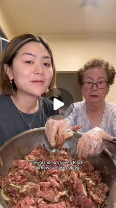 two women are cooking food in a pan