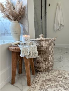 a white vase sitting on top of a table next to a basket