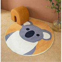 a rug with a koala bear on it in the corner next to a potted plant