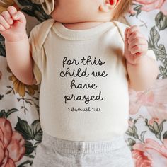 a baby laying on top of a bed wearing a white shirt that says i am proof that god creates miracles