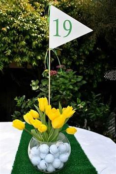 a vase filled with yellow flowers sitting on top of a white tablecloth covered field