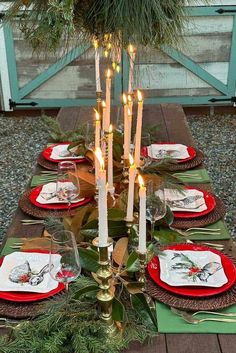 a christmas table setting with candles and plates