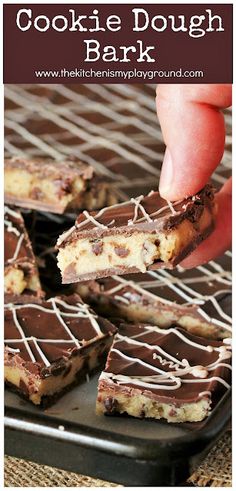 chocolate cookie dough bark is being held up by a hand over a plate with cookies on it