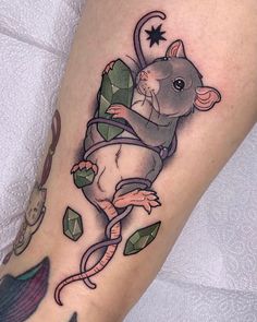 a tattoo with a rat on it's leg and some leaves around the legs