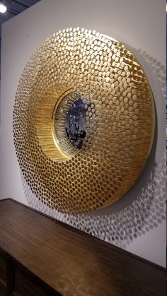 a large metal object sitting on top of a wooden table next to a white wall