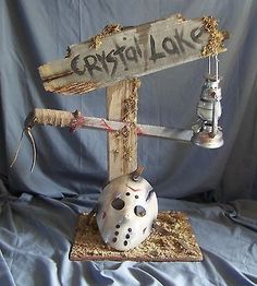 a wooden sign that says crystal lake with a hockey mask on it and a bell