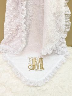 the monogrammed initials on this white ruffled dress are gold - plated