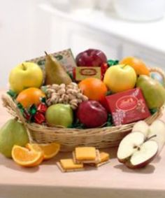 a basket filled with assorted fruit and crackers on top of a wooden table