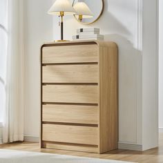 a wooden dresser sitting next to a lamp on top of a white rug in a room