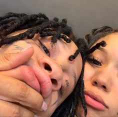 two women with dreadlocks covering their eyes and nose are posing for the camera