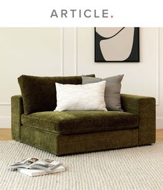 a green chair with two pillows on top of it and a white rug in front of it