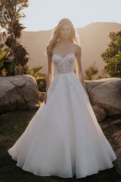 a woman in a wedding dress standing on grass