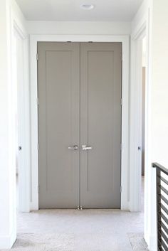 an empty hallway with two doors leading to another room in the same house or apartment