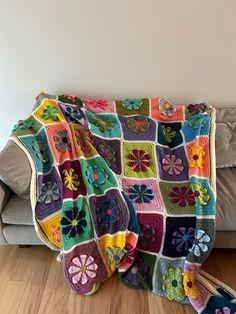 a crocheted granny blanket sitting on top of a couch