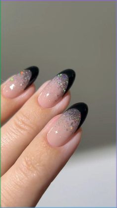 a woman's hand with black and white manies on her nails, with glitter in the middle