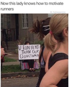 a woman holding a sign that reads, now this lady knows how to motivate runners u run better than our government