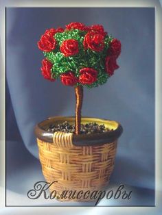 a small potted plant with red flowers on it's top and green leaves