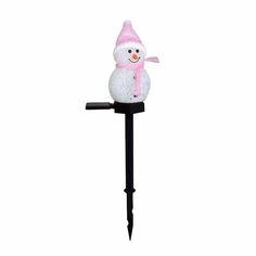 a snowman is sitting on top of a black pole with a pink hat and scarf