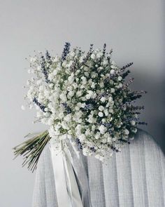 a bouquet of white flowers sitting on top of a chair