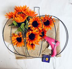 a bunch of sunflowers sitting on top of a burlap bag next to a pink blow dryer