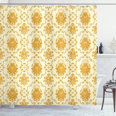 a yellow shower curtain with an ornate design