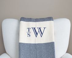 a blue and white towel sitting on top of a chair next to a pillow that says tw s