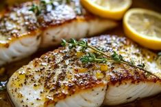 two fish fillets with herbs and lemons