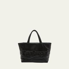 Saint Laurent tote bag in padded leather Rolled top handles, 7.48" drop Open top Embossed logo at front Internal zipper pocket Approx. 16.14"H x 16.92"W x 6.6"D  Made in Italy Leather Logo Bags For On-the-go, Leather Shoulder Bag With Logo For On-the-go, Luxury Bags With Logo For On-the-go, Luxury Logo Bags For On-the-go, Black Leather Satchel With Logo, Modern Leather Shoulder Bag With Embossed Logo, Leather Satchel With Logo And Top Handle, Leather Top Handle Satchel With Logo, Leather Tote Shoulder Bag With Logo