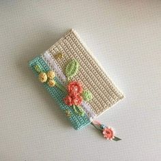 a crocheted book with flowers on it