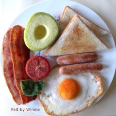 an egg, bacon, toast, and avocado on a plate with tomatoes