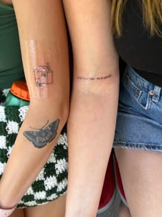 two women with tattoos on their arms