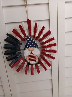 a wreath made out of popsicle sticks and an american flag decoration hanging on the front door