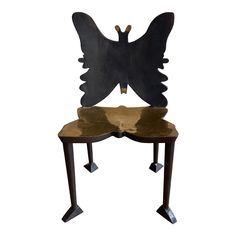 a chair with a butterfly shaped back and wings on it's legs, sitting in front of a white background