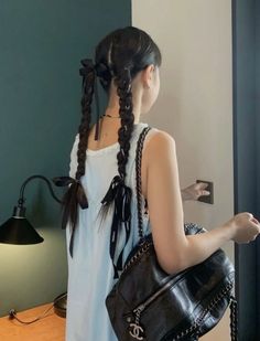 a woman with braids holding a black purse