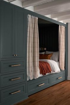 the bed is built into the side of the wall in this room with drawers and cupboards