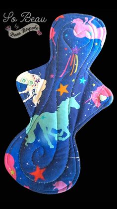 an oven mitt with unicorns on it and stars in the sky behind it