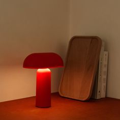 a red lamp sitting on top of a wooden table