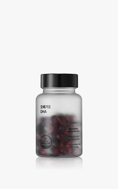 an open jar of vitamins on a white background with the lid down and some red berries in it