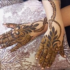 two hands with henna tattoos on them