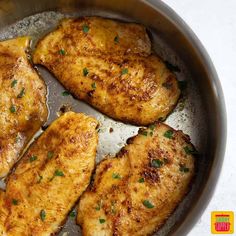 four pieces of chicken in a pan with some parsley on the top and one side