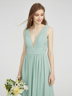 a woman in a long green dress holding a bouquet