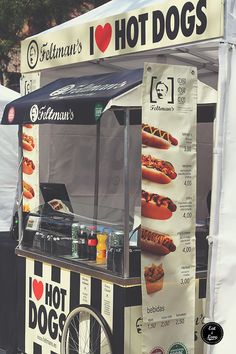 a hot dog cart with buns and ketchup on the side for sale